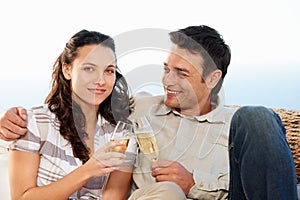 Couple, drinking champagne and toast for celebration and good news on honeymoon, announcement and love. Looking at wife