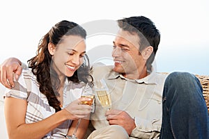 Couple, drinking champagne and toast for honeymoon and good news for celebration, announcement and love. Looking at wife