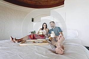 Couple drinking coconut and relaxing on the bed