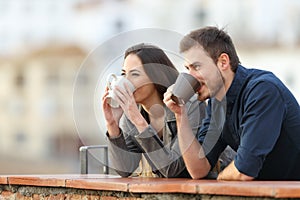 Couple drinking coffee contemplating views photo