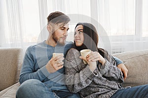 Couple drinking coffee in living room