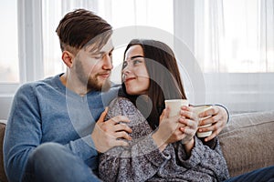 Couple drinking coffee in living room