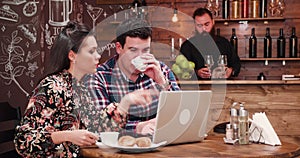 Couple drinking coffee and looking at computer screen