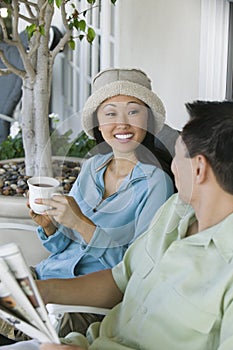 Couple drinking coffee and reading newspaper