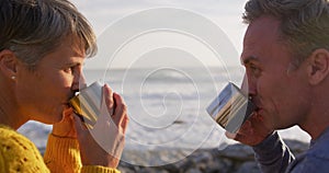 Couple drinking coffee by the sea