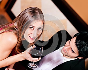 Couple drinking red wine clinking glasses