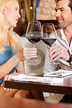 Couple drinking red wine in restaurant or bar