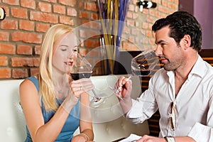 Couple drinking red wine in restaurant or bar