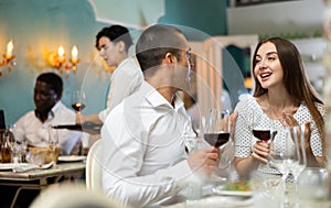 Couple drinking red wine in restaurant and talking