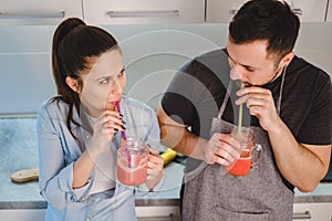 Couple drinking smoothie from the jar with a straw