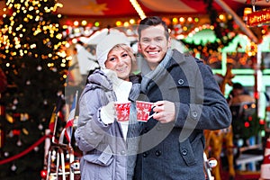 Couple drinking spiced wine on Christmas market