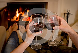Couple drinking wine in front of a fire