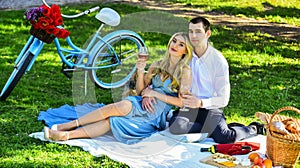 Couple drinking wine sunny day. Attractive Couple Enjoying Romantic Sunset Picnic in Countryside. Cute couple drinking