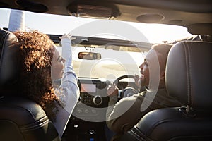 Couple drive looking at each other, rear passenger POV