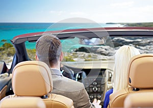 Couple driving in cabriolet car over sea shore