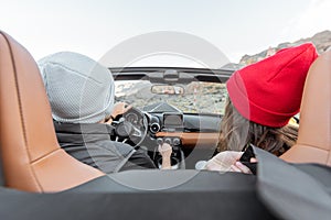 Couple driving a cabriolet while traveling