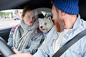 Couple driving by the car with their dog