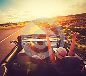 Couple Driving Convertable at Sunset photo