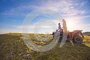 Couple driving off-road with quad bike or ATV