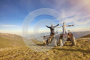 Couple driving off-road with quad bike or ATV