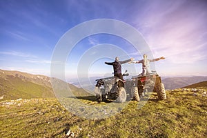 Couple driving off-road with quad bike or ATV