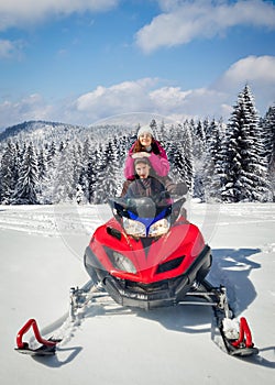 Couple driving snowmobile