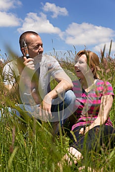 Couple with e-cigarette in a meadow