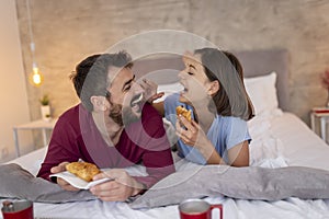 Couple eating breakfast in bed