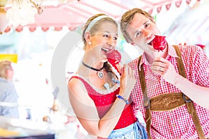 Couple eating candy apples at Oktoberfest