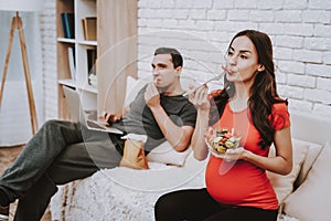 Couple is Eating and Drinking on Couch