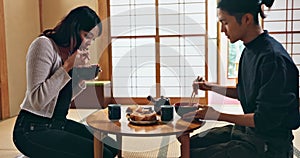 Couple, eating food for nutrition and Japanese people on date, dinner or lunch with love together in Tokyo. Hungry for