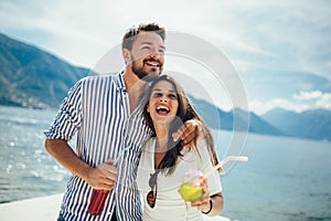 Couple eating fruit on the beach- summer party with friends and healthy food concept