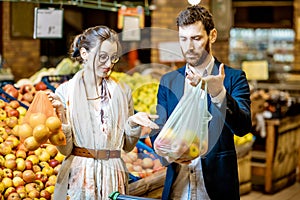 Couple with eco and plastic bag in the supermarket