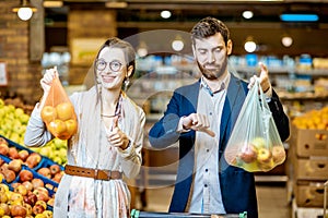 Couple with eco and plastic bag in the supermarket