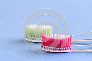 A couple of ecological plastic toothbrushes on the blue background close-up, isolated photo