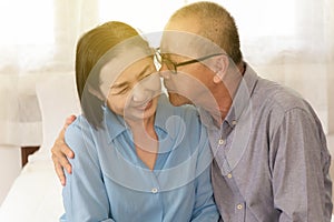 Couple Elderly man kisses cheek woman showing happy and love the morning in bedroom