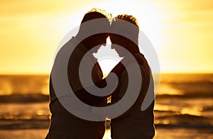 Couple, elderly and silhouette at beach with hug in sunset, evening or dusk by water, waves or horizon together. Senior