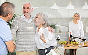 Couple of elderly man and woman greeting friends