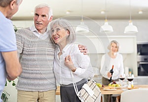 Couple of elderly man and woman greeting friends