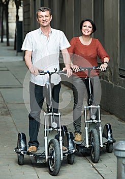 Couple with electrkc bikes in vacation on city street