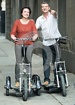 Couple with electrkc bikes in vacation on city street