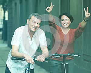 Couple with electrkc bikes in vacation on city street