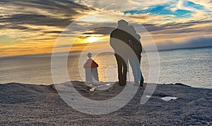 couple embrace looking a sunset in nordic country. Traveling on Honeymoon
