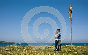 Couple embraced by a direction sign