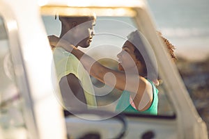 Couple embracing each other near camper van at beach
