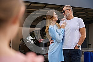 Couple embracing look at each other, standing near new house