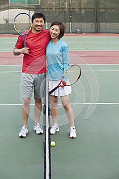 Couple embracing next to the tennis net