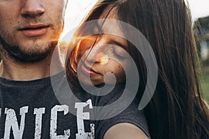 Couple embracing in summer sunset. woman holding head on her man