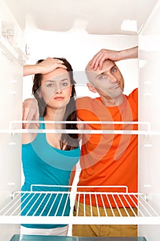 Couple with empty refrigerator