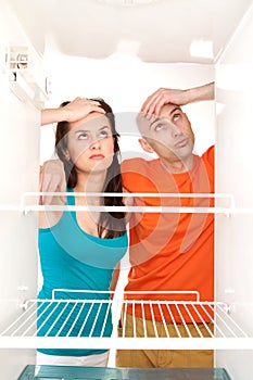 Couple with empty refrigerator